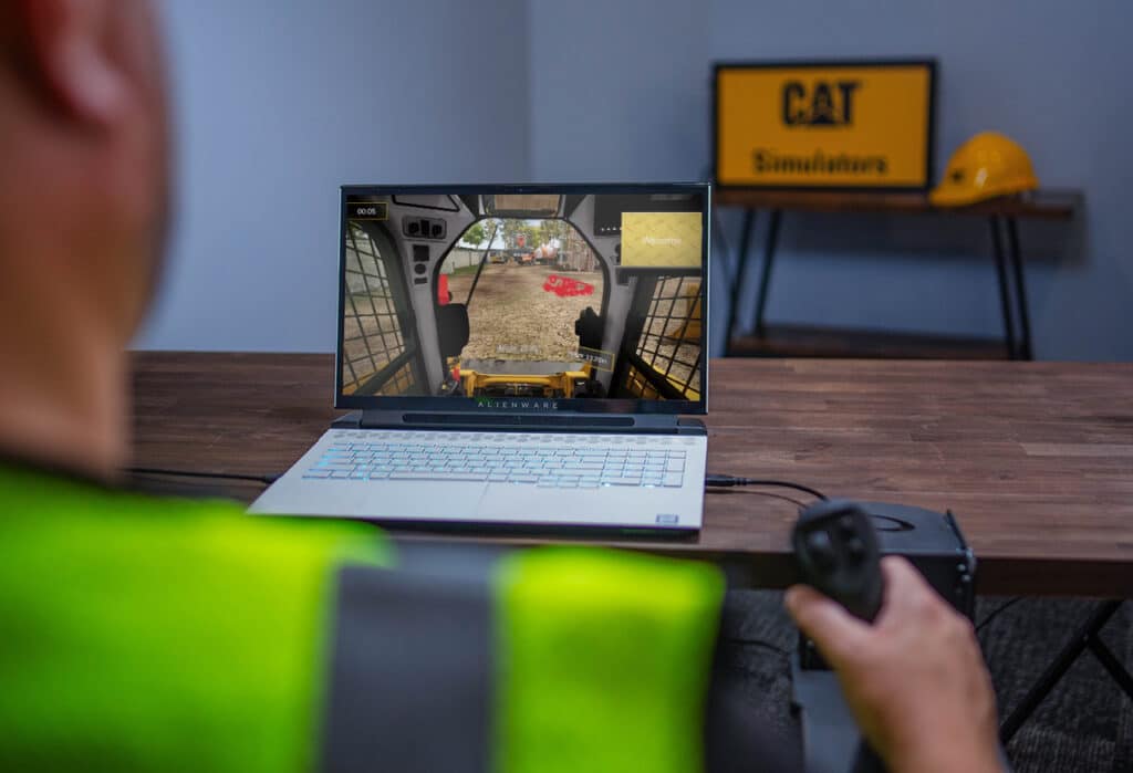 Operator using a laptop with SimLite Dozer for simulator operator training
